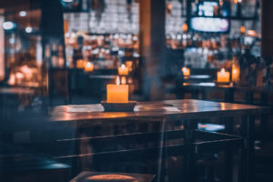 Innenansicht eines Restaurants mit leeren Tischen und Kerzenlicht