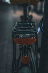 Dunkle Aufnahme von einem Gepäckträger eines Fahrrads mit Rücklichtern und Rückstrahler